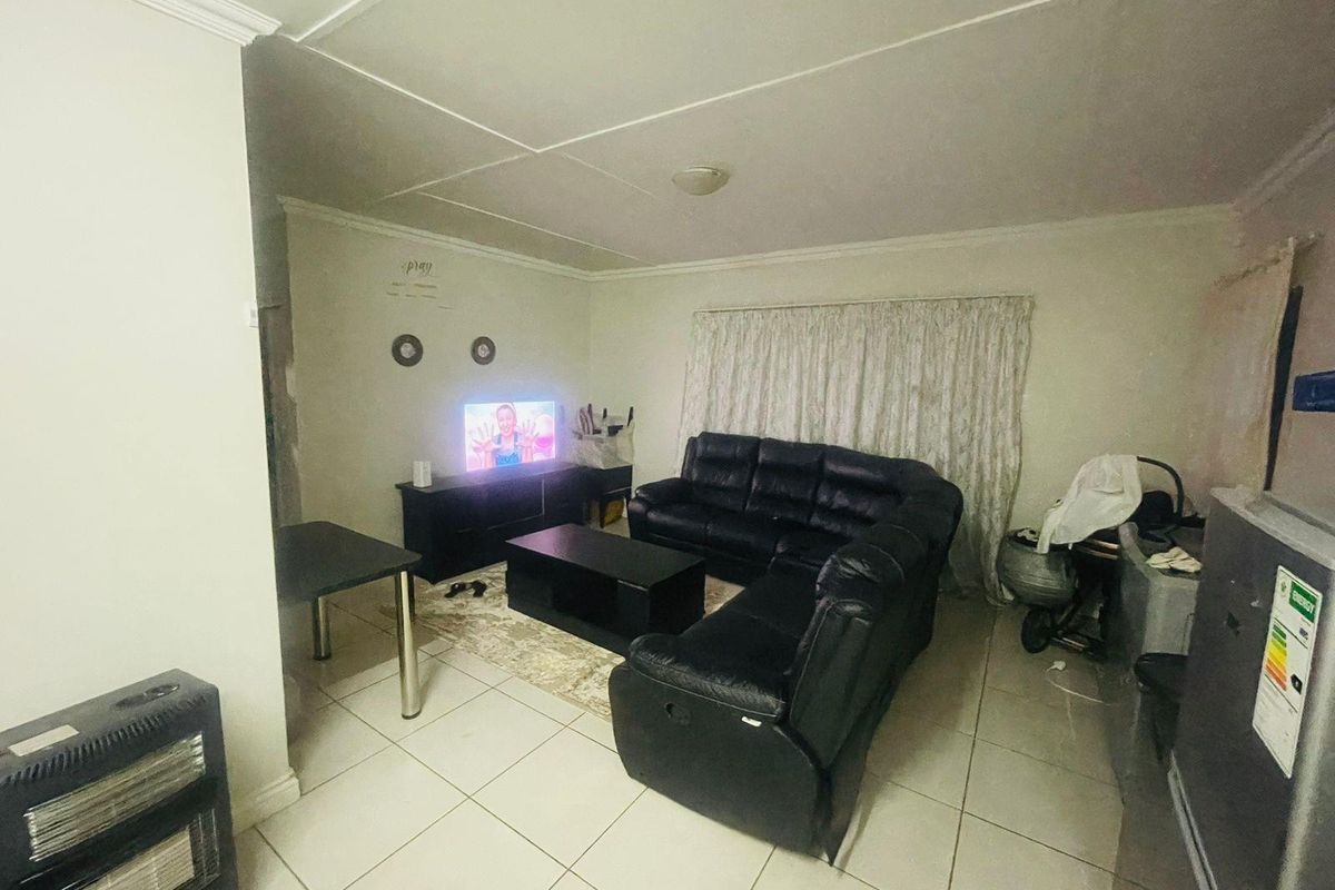 A functional living room featuring tiled flooring and standard ceiling finishes, providing a neutral base for potential interior updates.