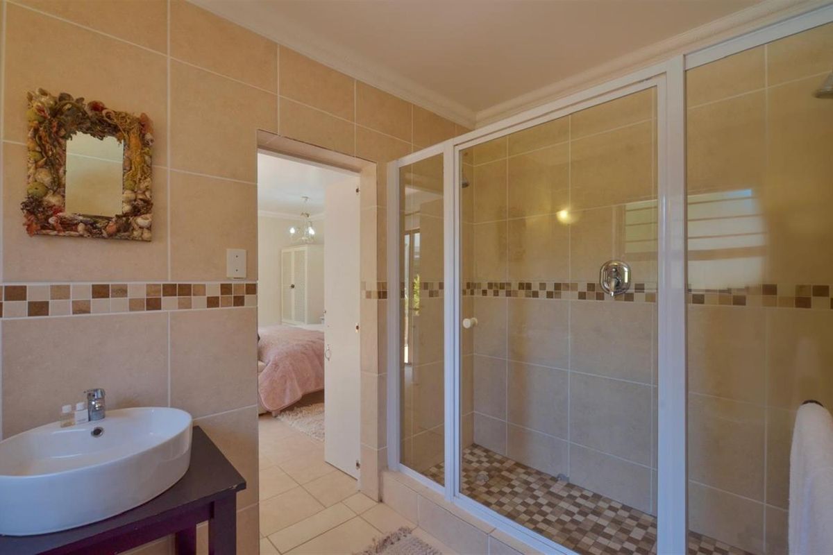 A functional bathroom featuring a walk-in shower with glass enclosure, tiled walls, and a modern vessel sink vanity.