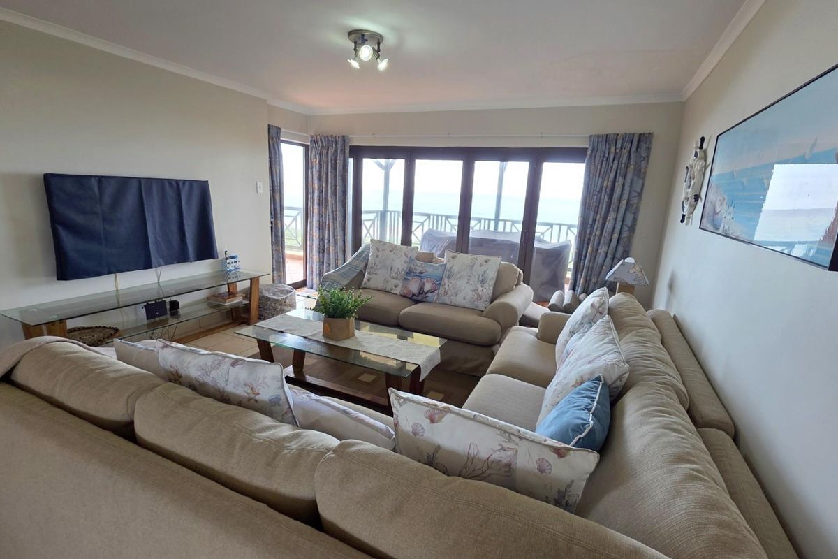 Spacious living room featuring large sliding glass doors that provide natural light and direct access to the balcony with ocean views.