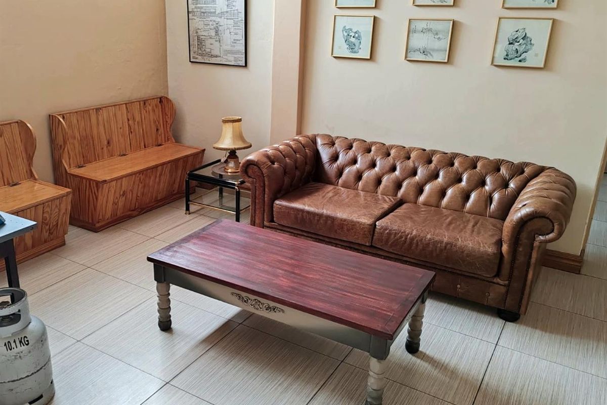 A comfortable living area featuring neutral wall tones and light-colored ceramic floor tiles, providing a functional space for commercial or office use.