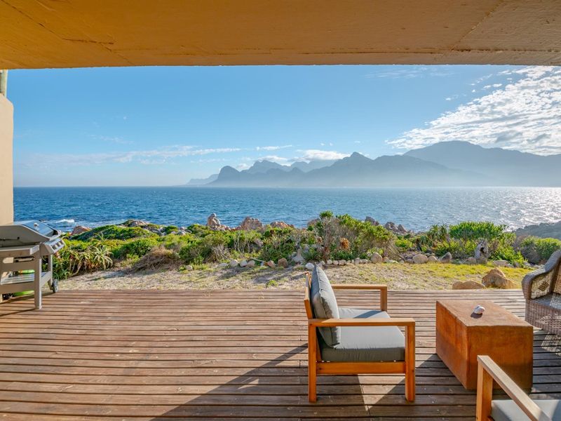 Covered timber deck patio offering expansive ocean and mountain views, providing a seamless transition to the natural coastal landscape.