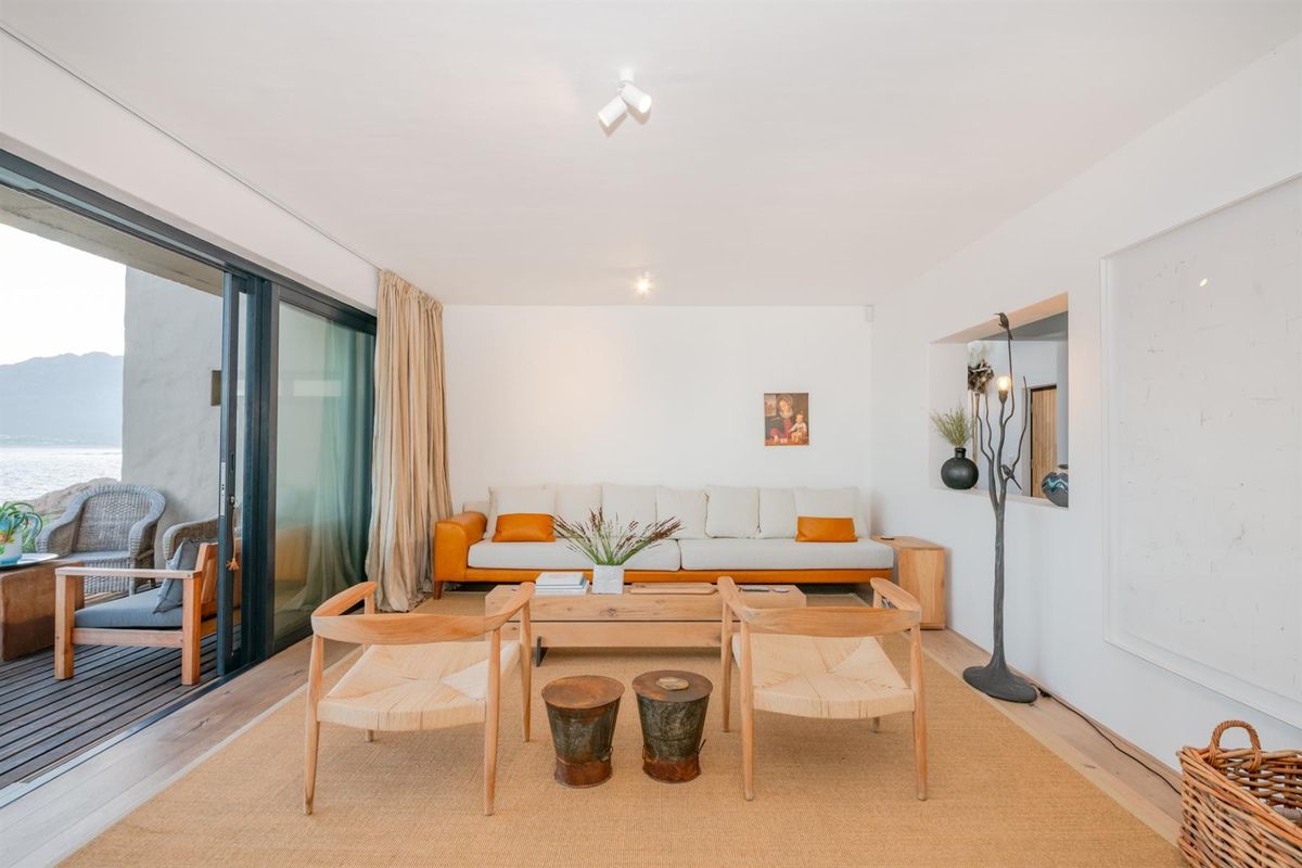 Bright and airy living room featuring hardwood flooring, a recessed wall niche, and large sliding glass doors that open onto an outdoor patio area.