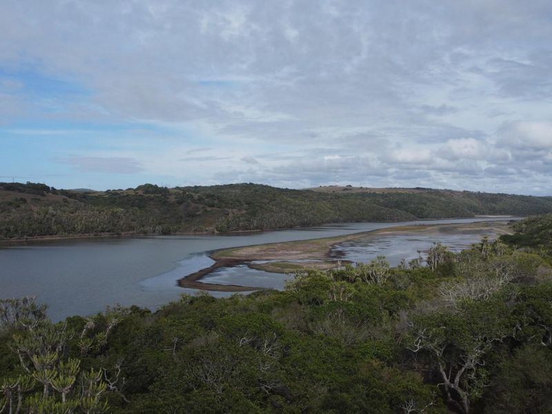An elevated aerial view showcasing the natural landscape, river, and surrounding vegetation of the vacant residential land.