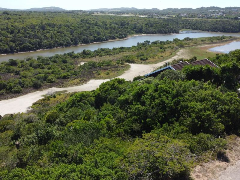 Aerial view of a residential property featuring natural vegetation, a river landscape, and proximity to coastal surroundings.