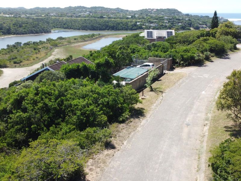Aerial view of the residential property showing the surrounding landscape, access road, and proximity to the nearby estuary and coastal area.