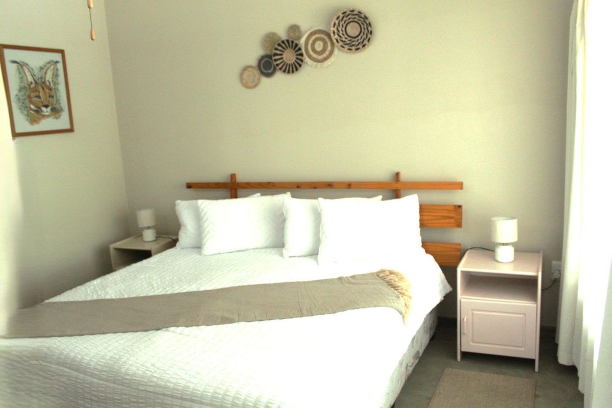 A well-lit bedroom featuring neutral wall tones and tiled flooring, providing a comfortable and functional living space.