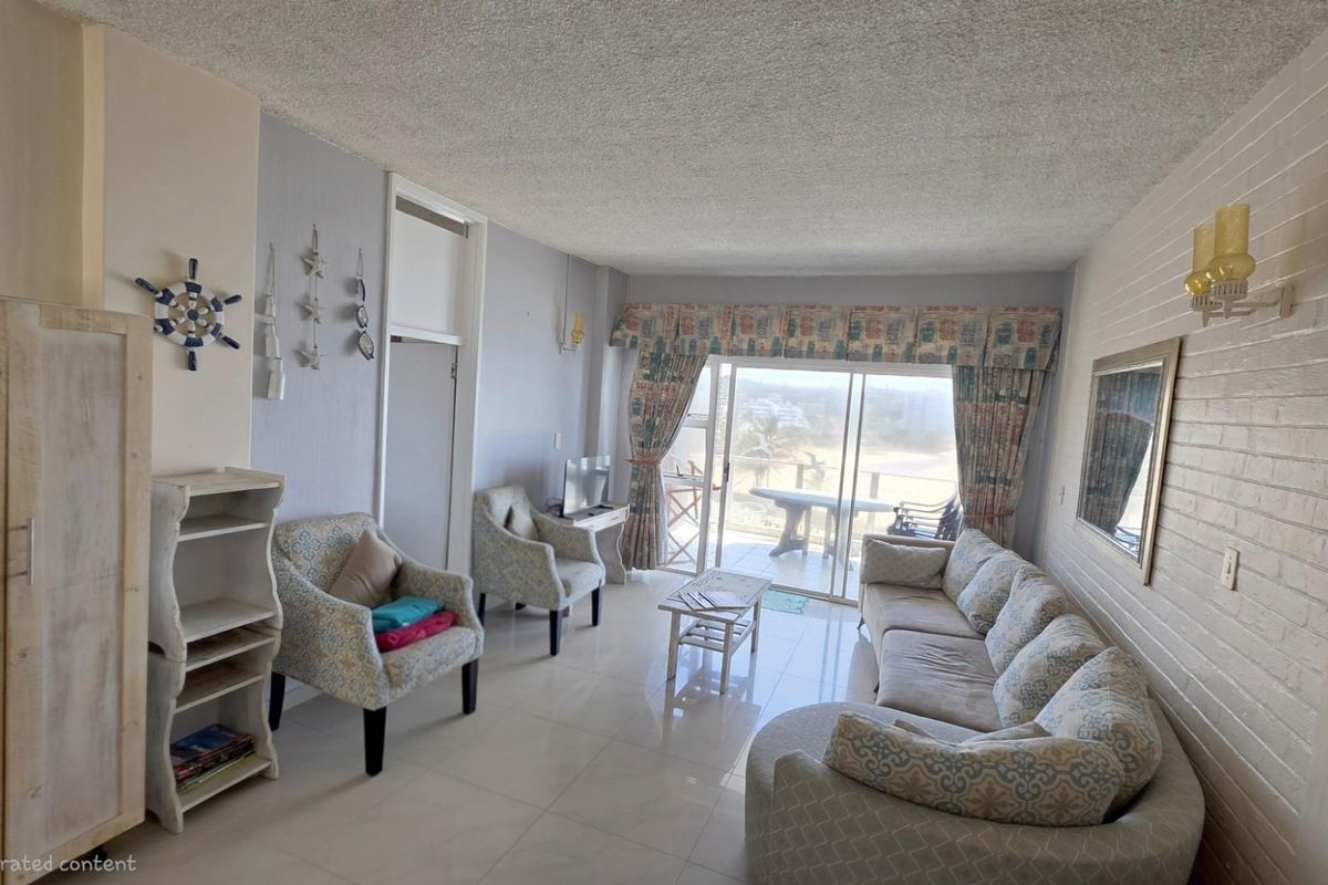 A spacious living room featuring tiled flooring, a textured ceiling, and large sliding glass doors that provide access to an outdoor balcony area.