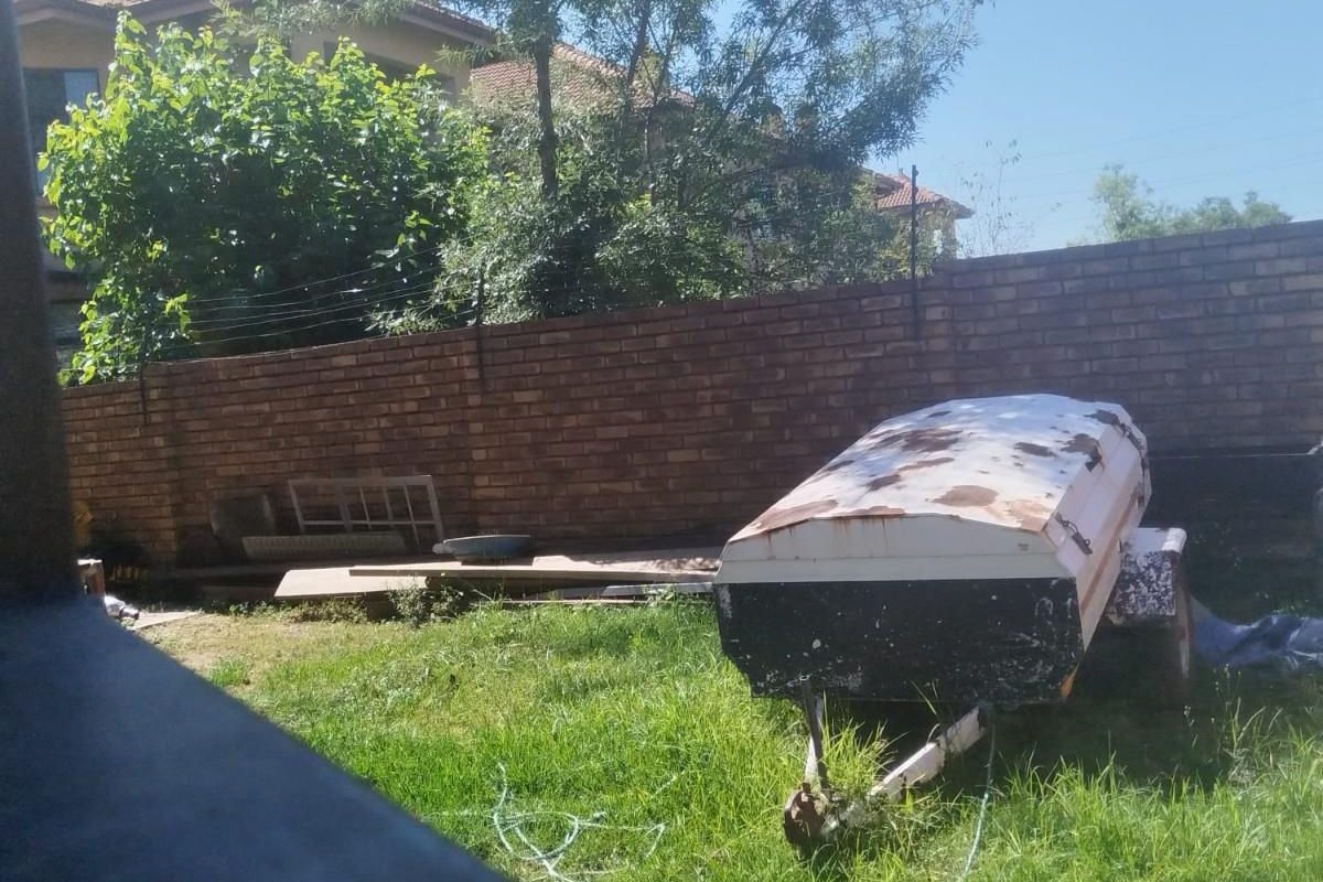 A view of the rear garden area featuring a brick boundary wall and lawn space.