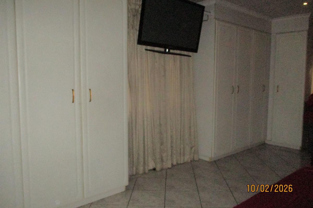 A bedroom featuring built-in cabinetry and tiled flooring, providing functional storage space within the room.