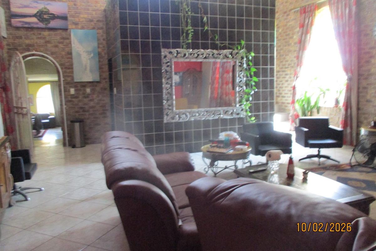 Spacious living area featuring exposed brick walls, high ceilings, and a central tiled feature wall with an arched doorway leading to adjacent rooms.