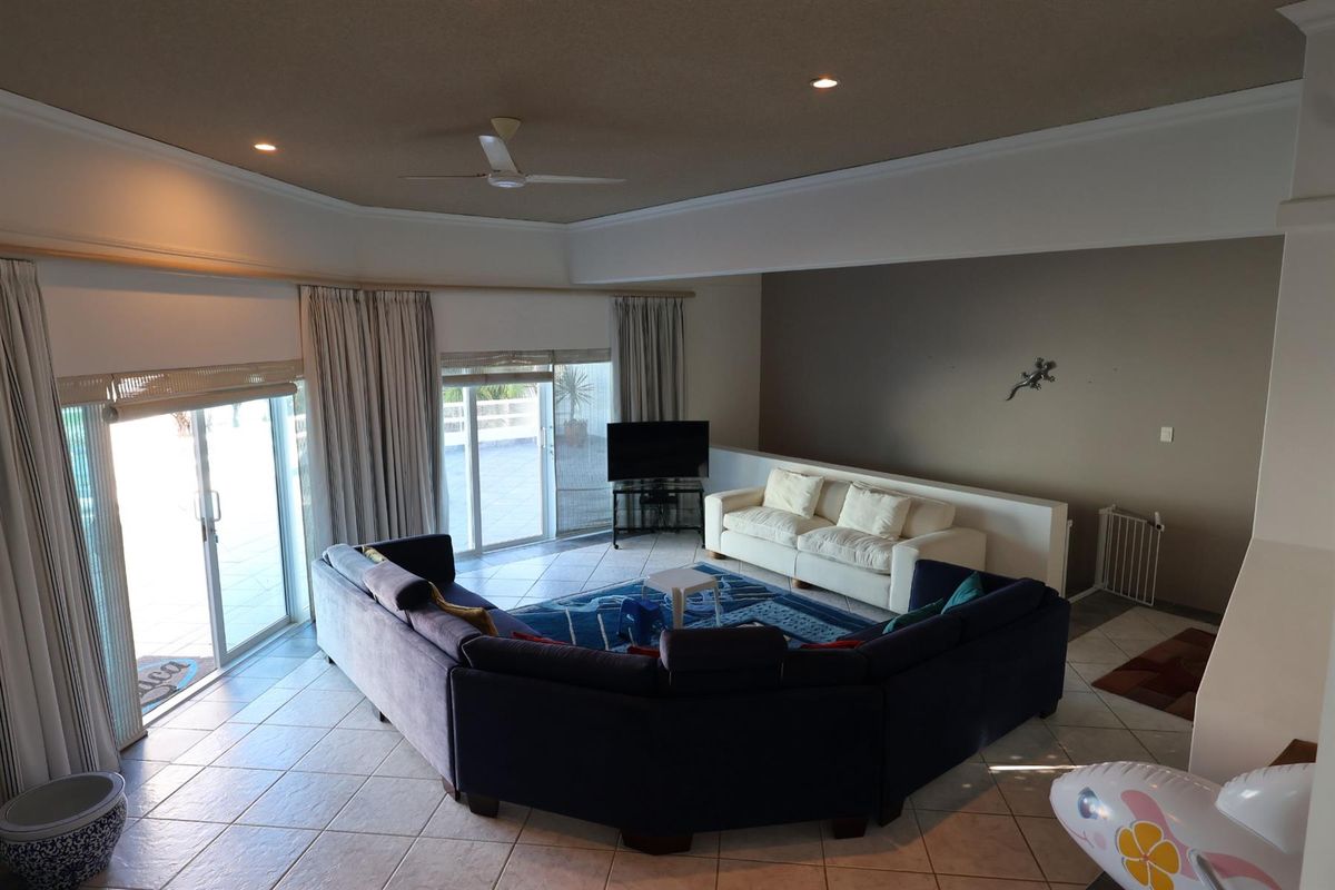 Spacious living area featuring tiled flooring, recessed ceiling lighting, a ceiling fan, and large sliding glass doors providing access to the outdoor patio.