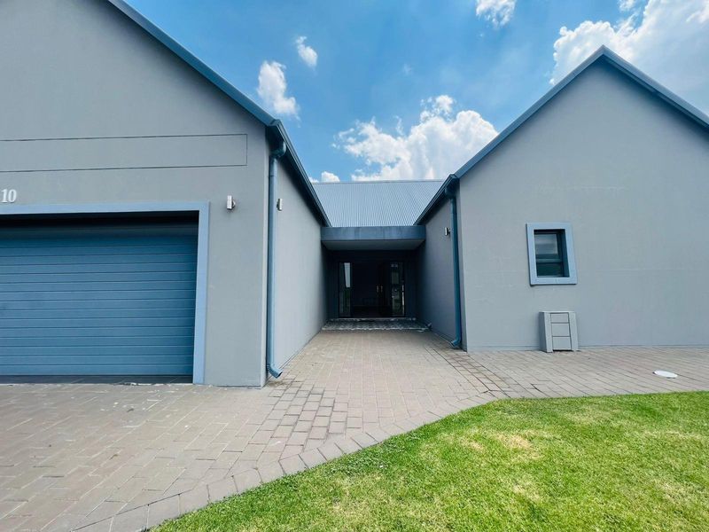 Modern front facade featuring a paved driveway, integrated garage, and a recessed entrance area with clean architectural lines.