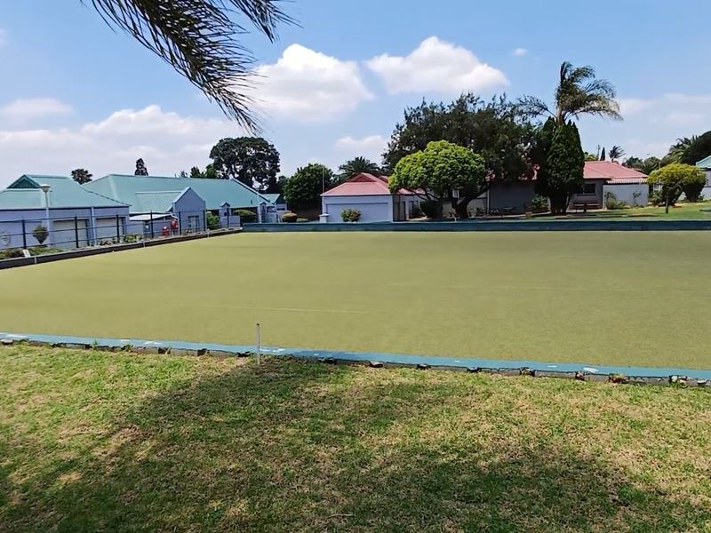 A well-maintained outdoor bowling green situated within the retirement village grounds, surrounded by residential units and landscaped gardens.