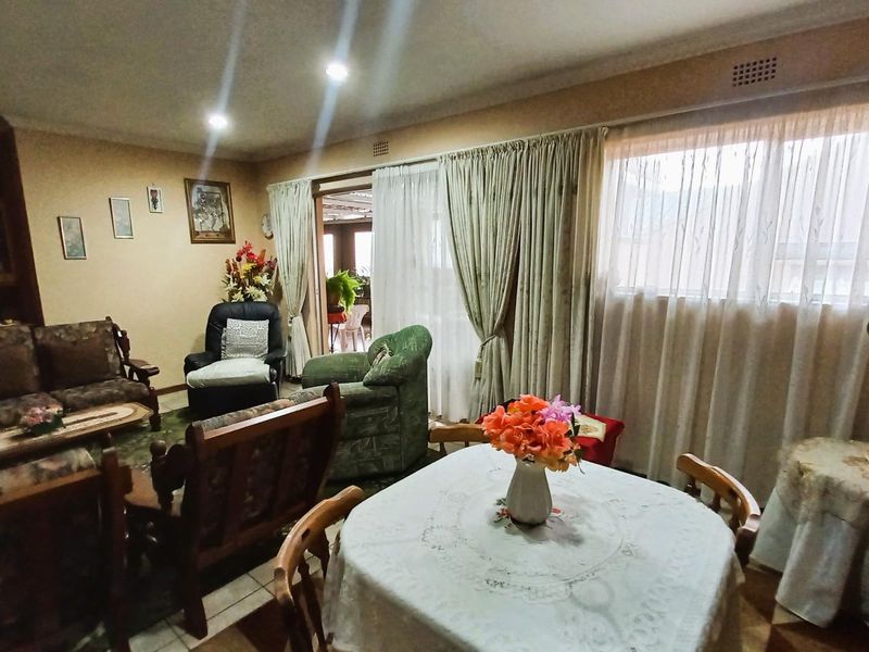 Spacious open-plan living and dining area featuring tiled flooring, recessed lighting, and a sliding glass door providing access to the outdoor space.