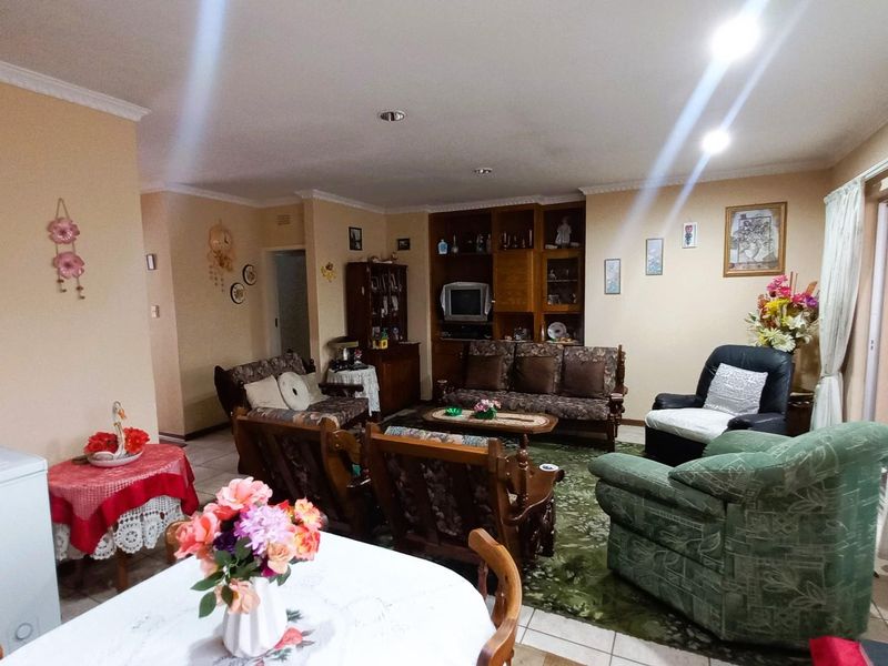 Spacious open-plan living and dining area featuring tiled flooring, recessed lighting, and built-in cabinetry, with direct access to an outdoor space.