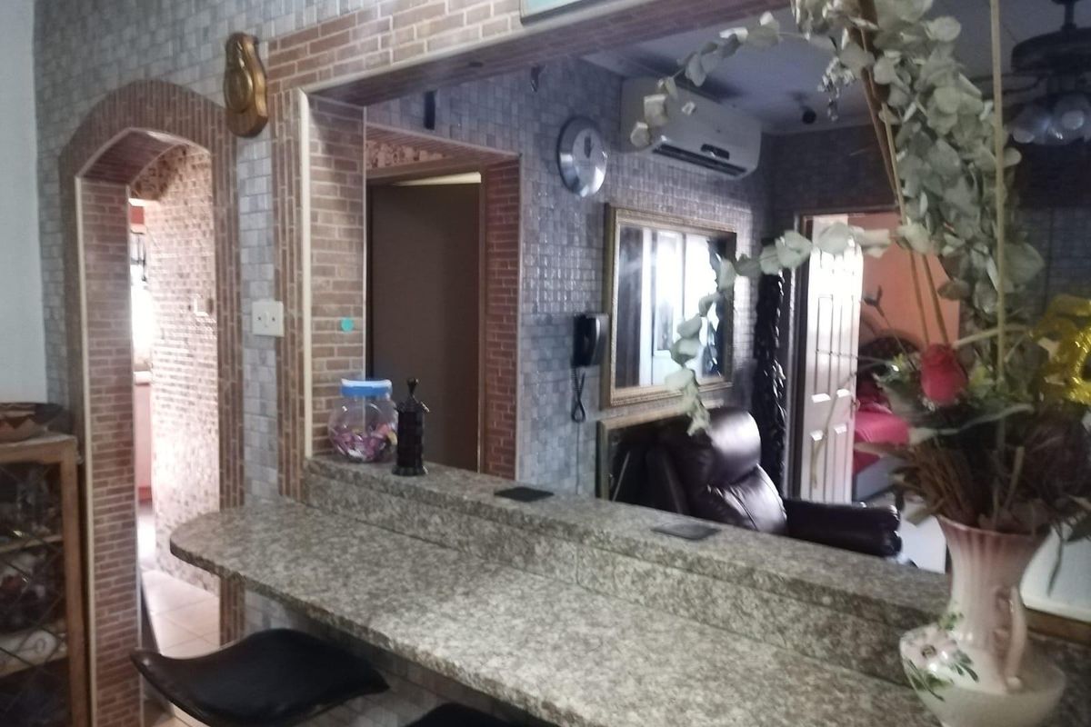 Interior view of a living area featuring a granite-topped breakfast bar, arched doorway, and wall-mounted air conditioning unit.