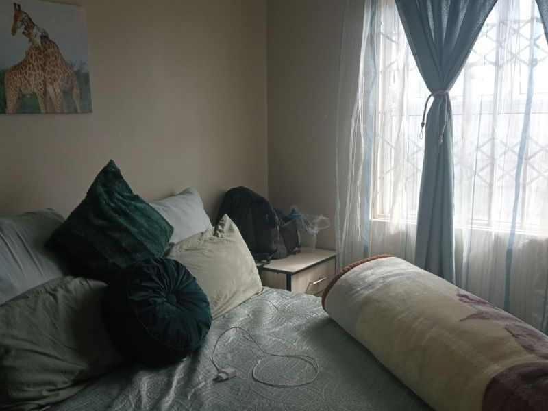 A standard bedroom featuring a window with an integrated security gate, providing natural light and essential security features.