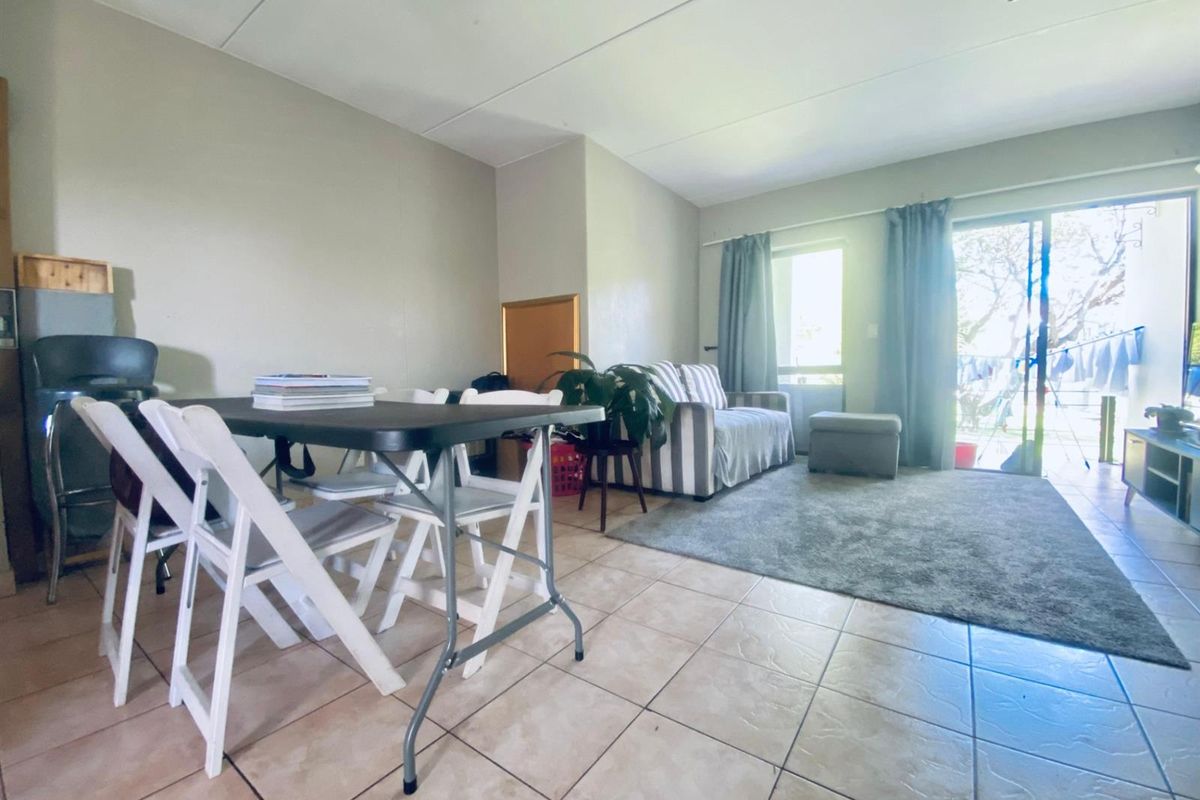 A living room area featuring tiled flooring and a sliding glass door providing access to an outdoor space.