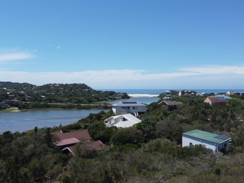 An elevated aerial view showcasing the coastal landscape, surrounding residential properties, and proximity to the river estuary and ocean.