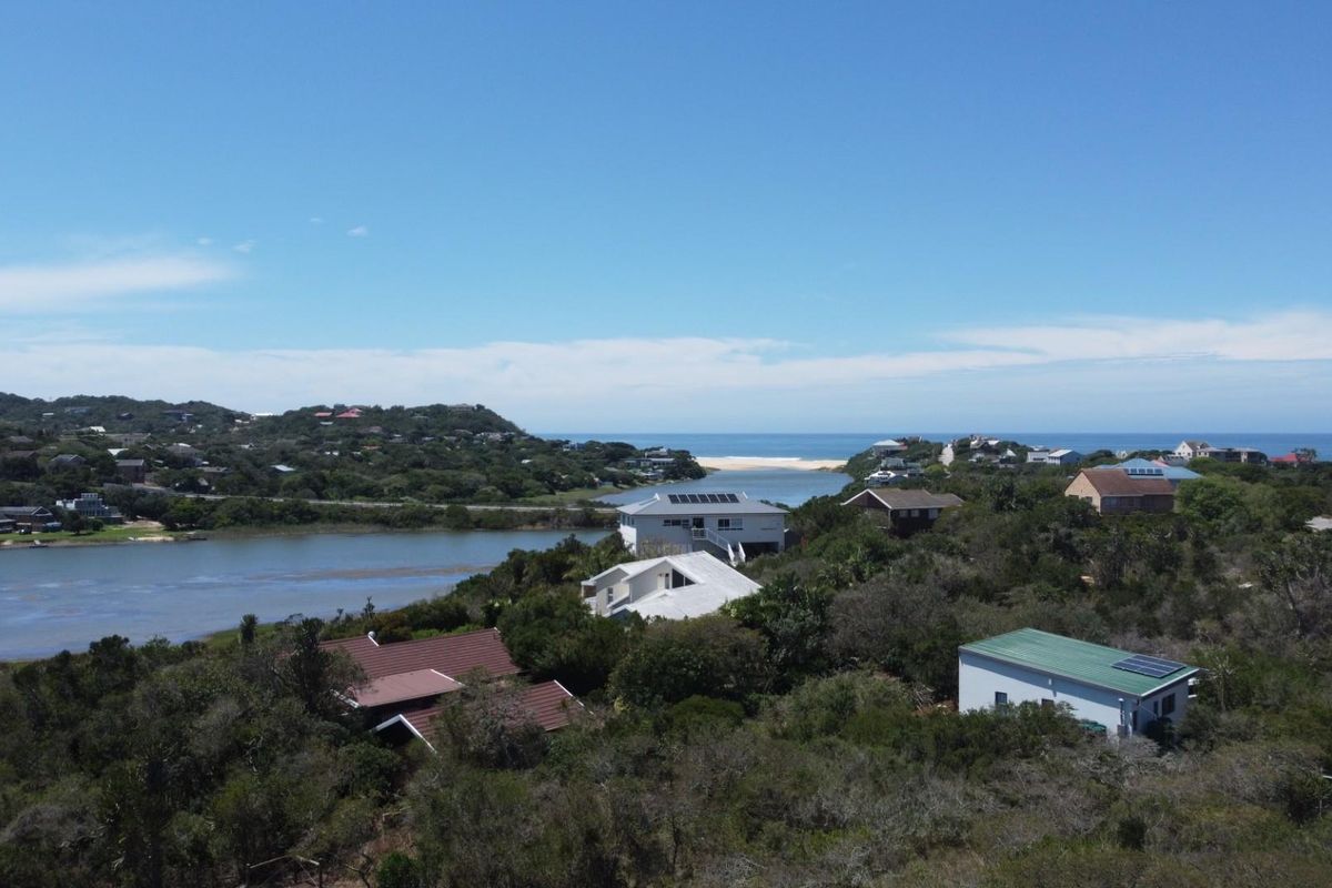 An elevated aerial view showcasing the coastal landscape, surrounding residential properties, and proximity to the river estuary and ocean.