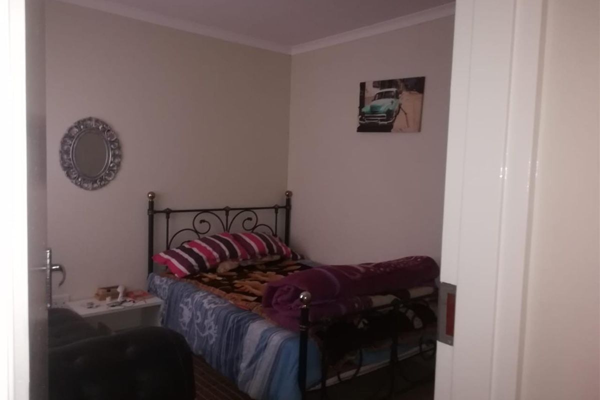 A standard bedroom featuring neutral wall tones and coved ceiling detailing, viewed from the doorway.
