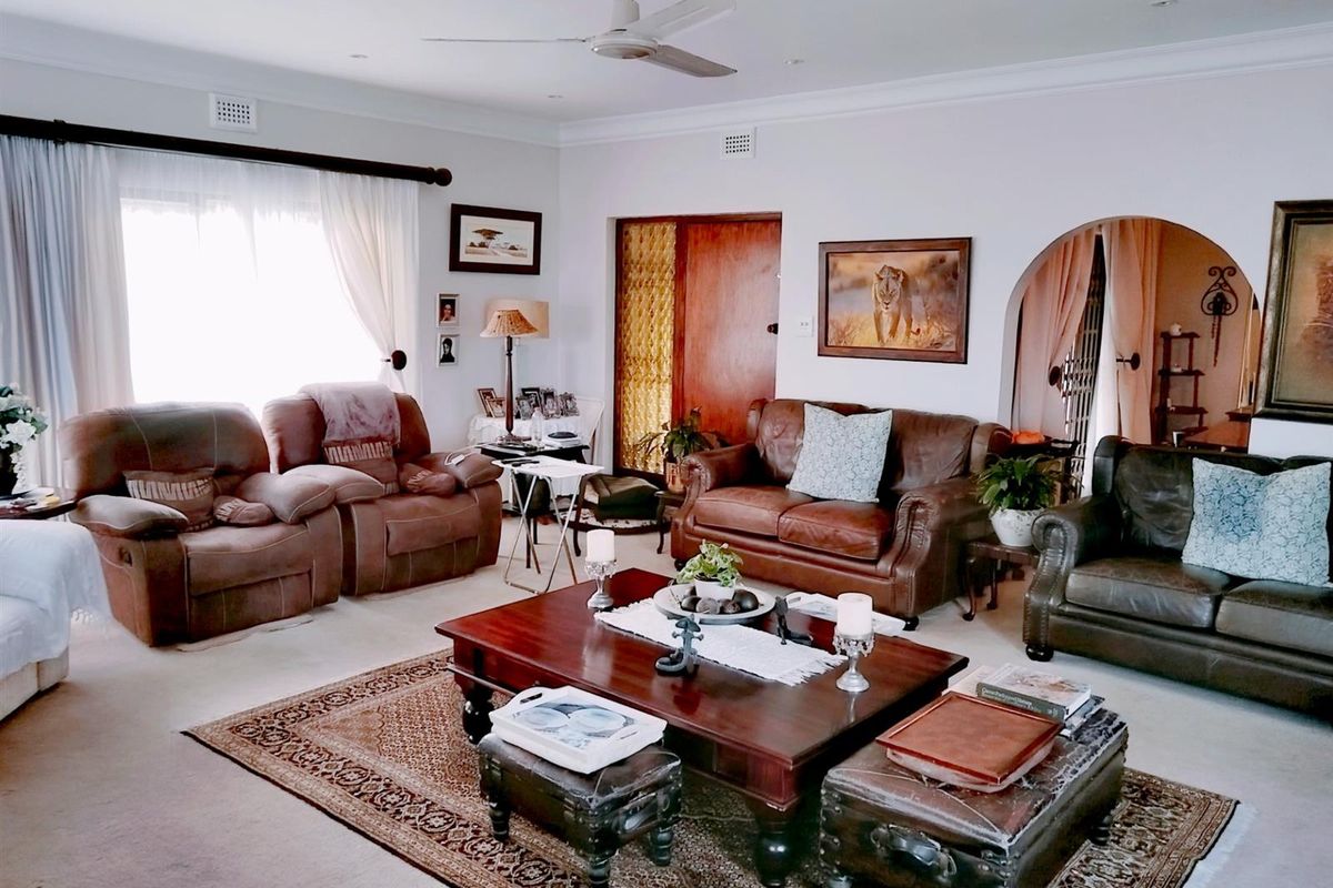Spacious living room featuring a ceiling fan, recessed lighting, and a distinctive arched doorway leading to an adjacent area.