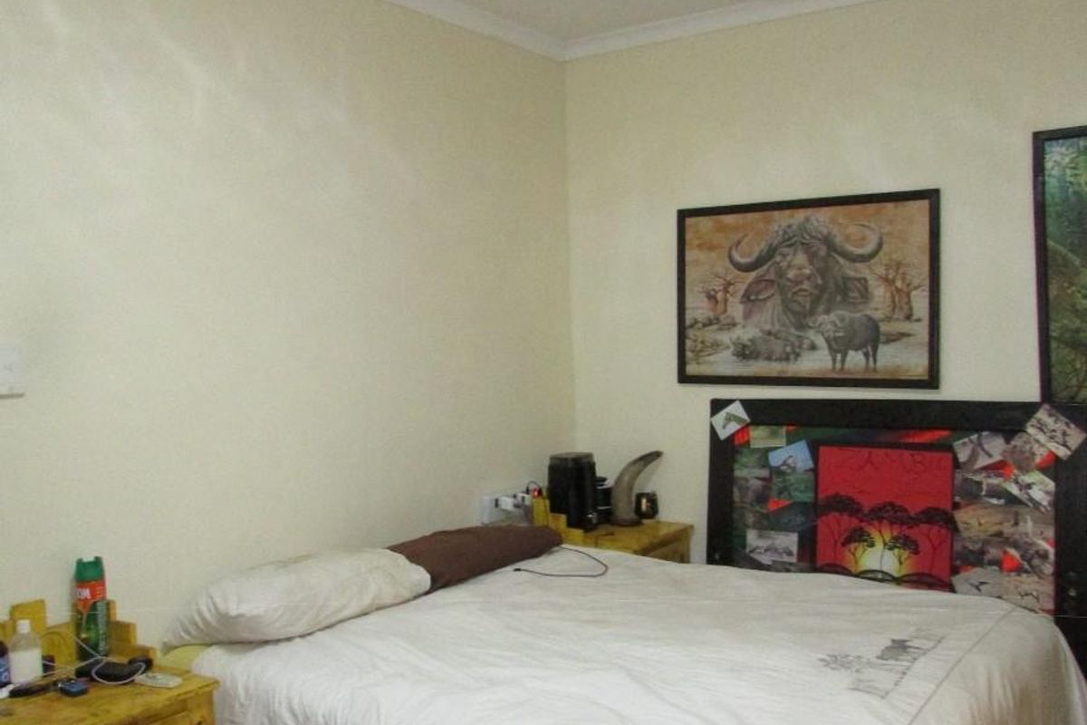 A functional bedroom featuring tiled flooring and standard ceiling finishes, providing a comfortable and practical living space.