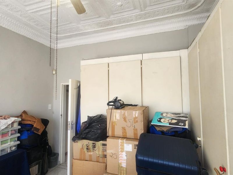 A bedroom featuring a decorative pressed metal ceiling and extensive built-in storage cupboards.