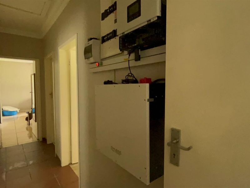 A hallway featuring a wall-mounted solar inverter and battery storage system, providing essential power infrastructure for the home.