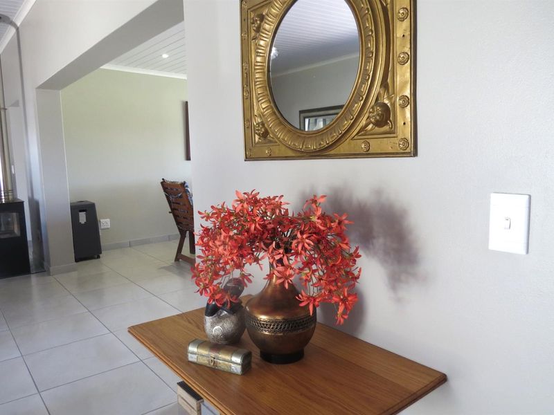 A bright hallway featuring tiled flooring, a wood-burning fireplace with a flue, and a tongue and groove ceiling.
