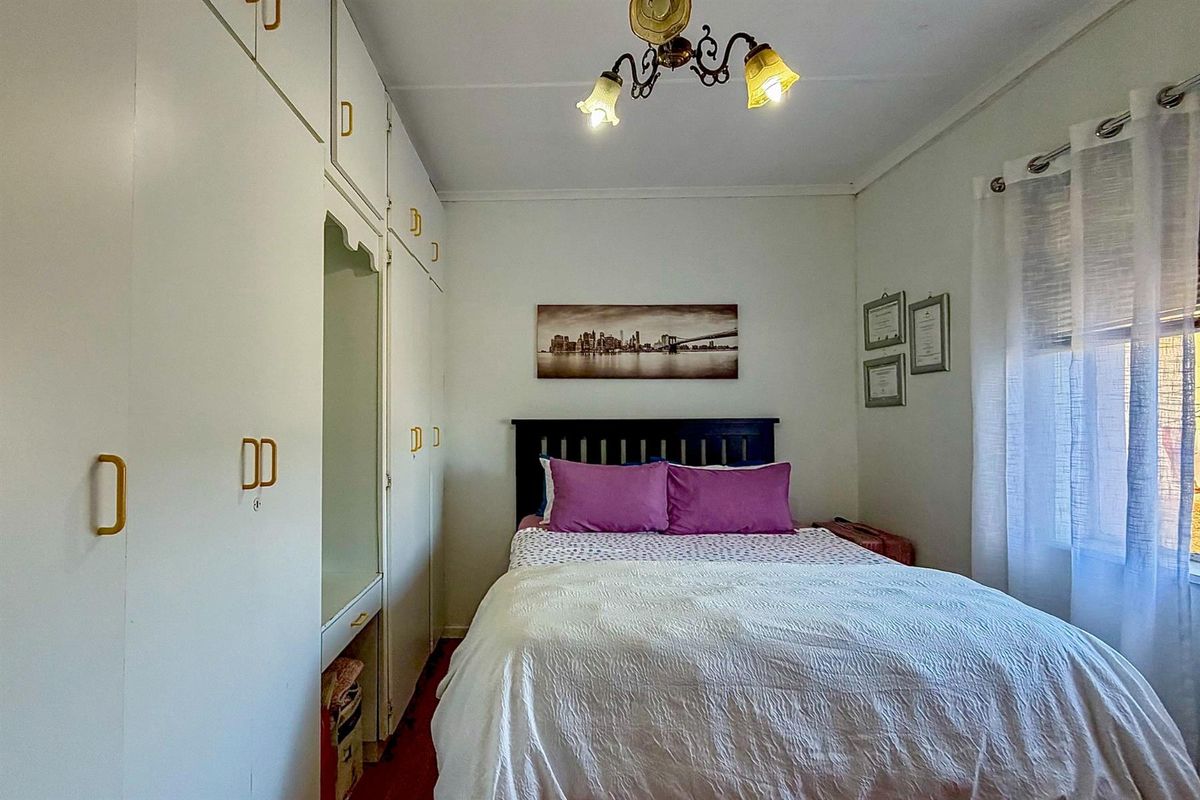 A bedroom featuring built-in floor-to-ceiling cabinetry with integrated shelving and a window with natural light.