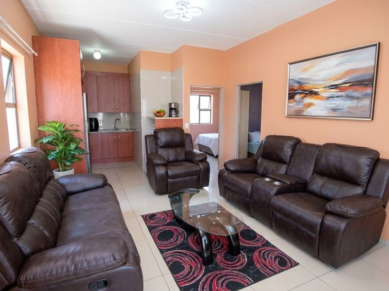 Open-plan living area featuring tiled flooring and an integrated kitchen with built-in cabinetry, providing a functional and connected space for daily living.