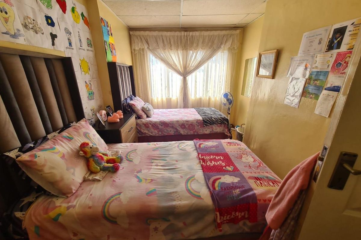 A bedroom featuring a drop ceiling, window with curtains, and space for two beds.