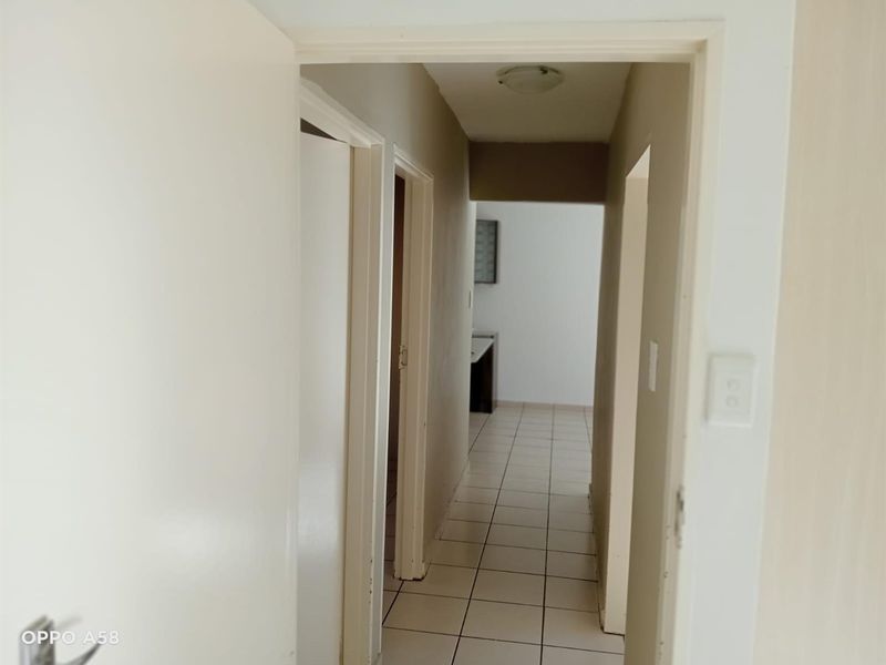 A functional hallway with tiled flooring connecting various rooms within the apartment.