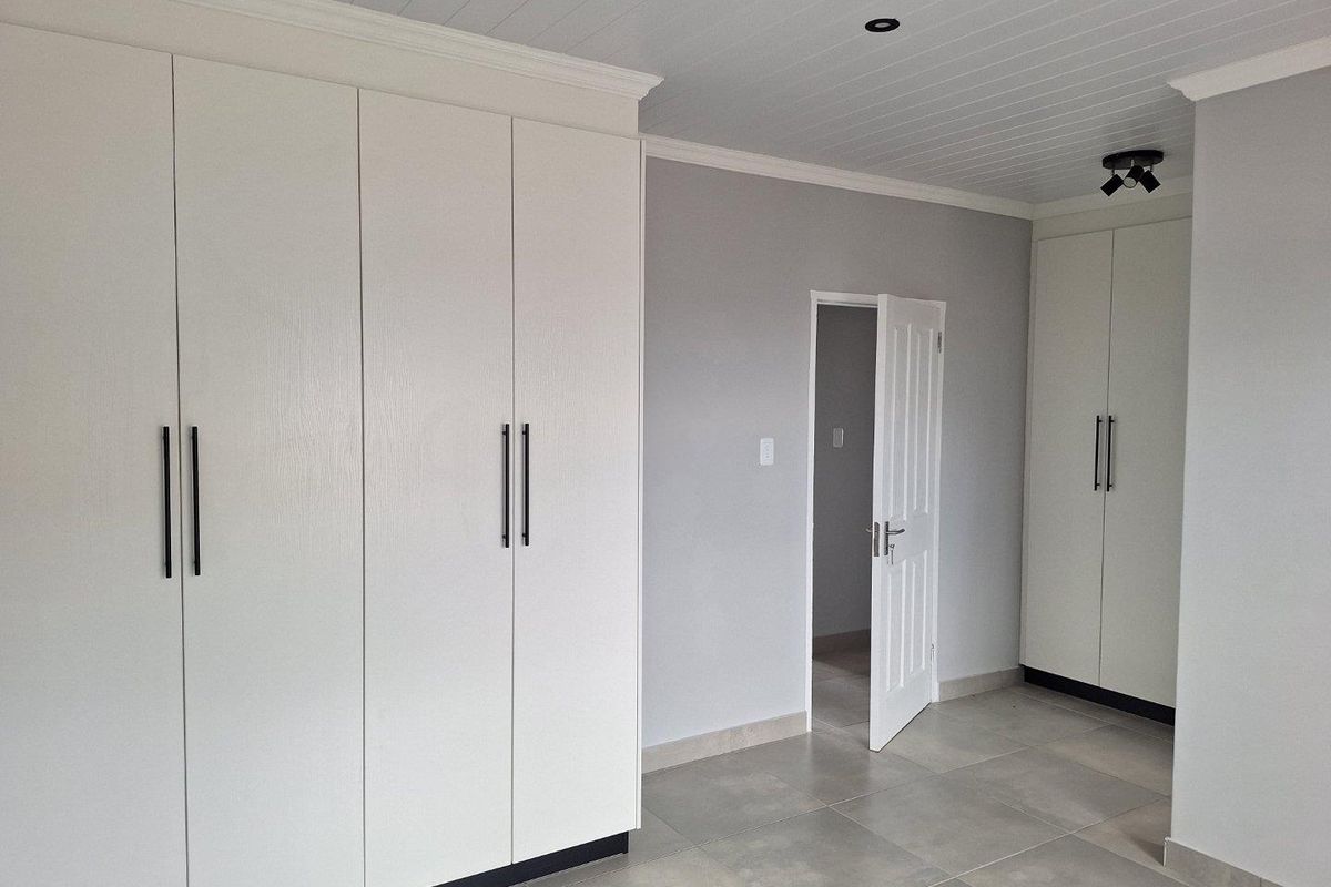 A modern bedroom featuring extensive built-in cabinetry, tiled flooring, and a tongue-and-groove ceiling with recessed lighting.