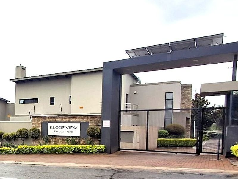 Front elevation of Kloof View property featuring a modern security gate, stone cladding accents, paved driveway, and roof-mounted solar panels.