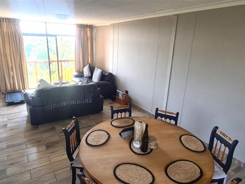 Open-plan living and dining area featuring tiled flooring and large sliding glass doors leading to a balcony, providing ample natural light.