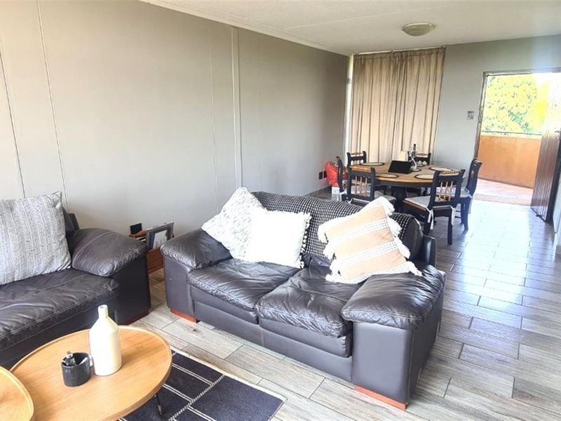 Open-plan living and dining area featuring tiled flooring and direct access to an outdoor balcony space.