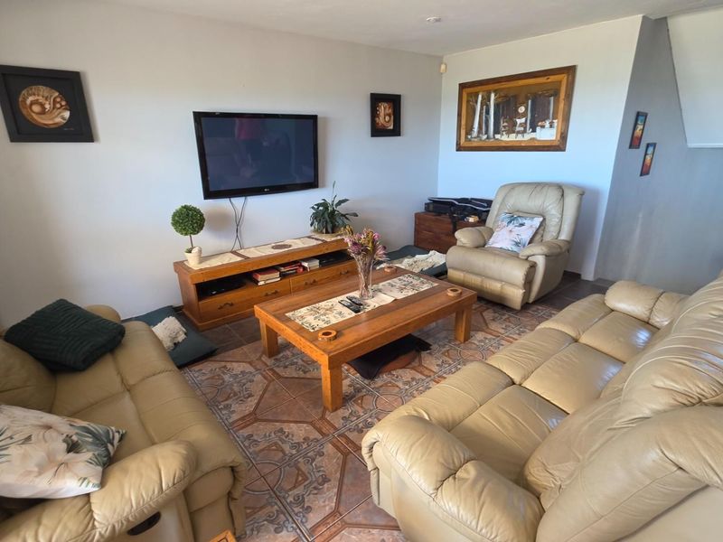A comfortable living room featuring tiled flooring and a wall-mounted television setup.