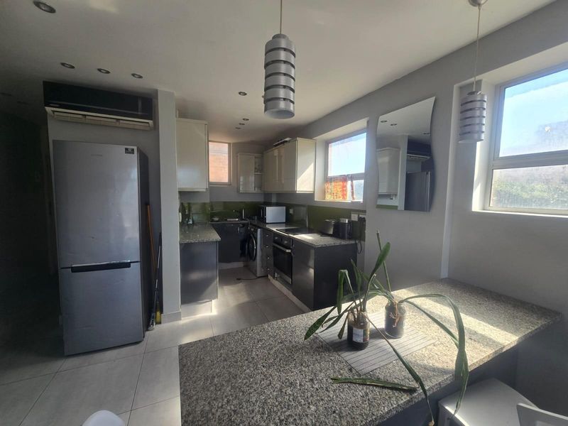 A functional kitchen featuring granite countertops, built-in cabinetry, integrated appliances, and recessed lighting, providing a clean and practical cooking space.