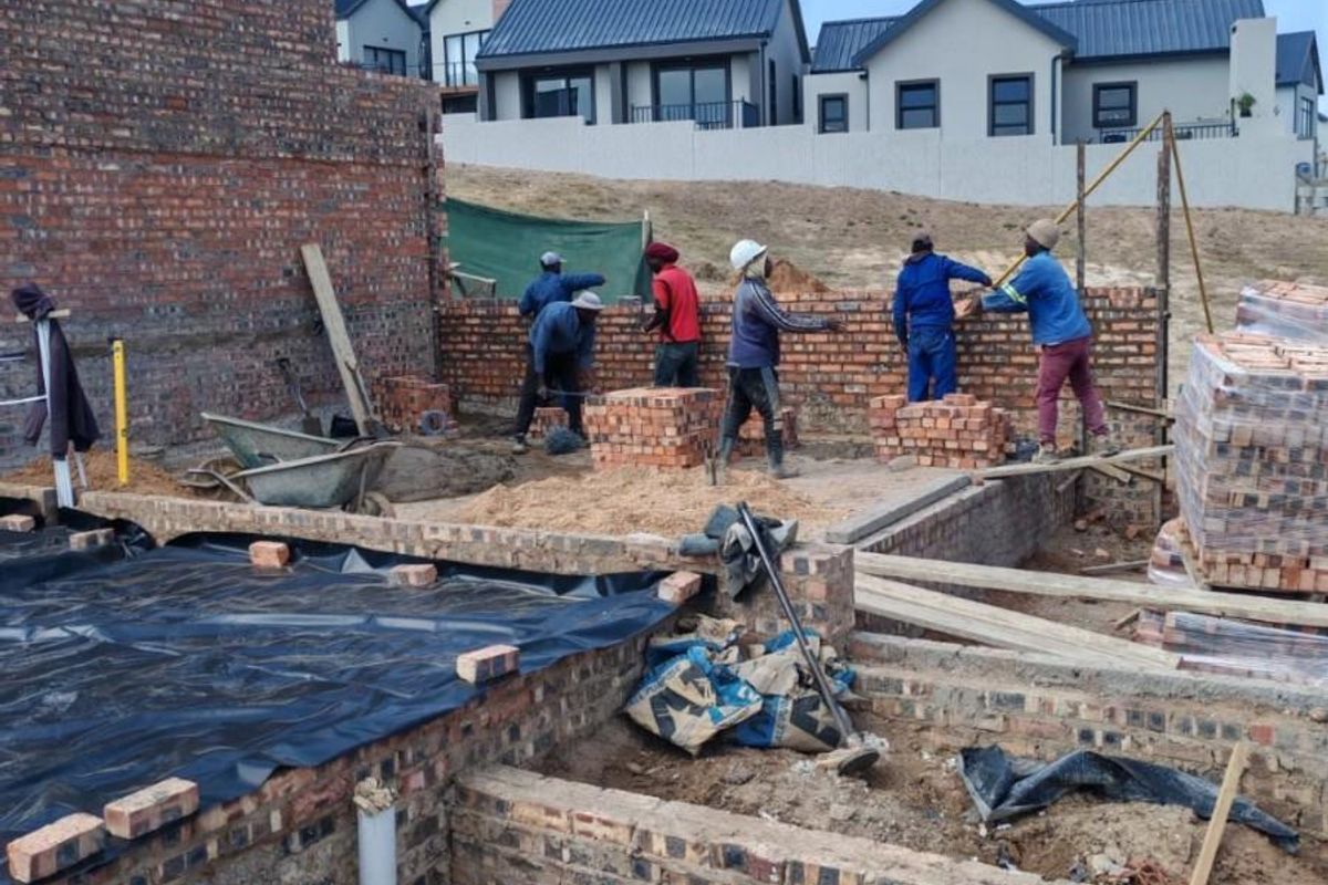 Construction site showing ongoing brickwork and foundation development for a new residential property.