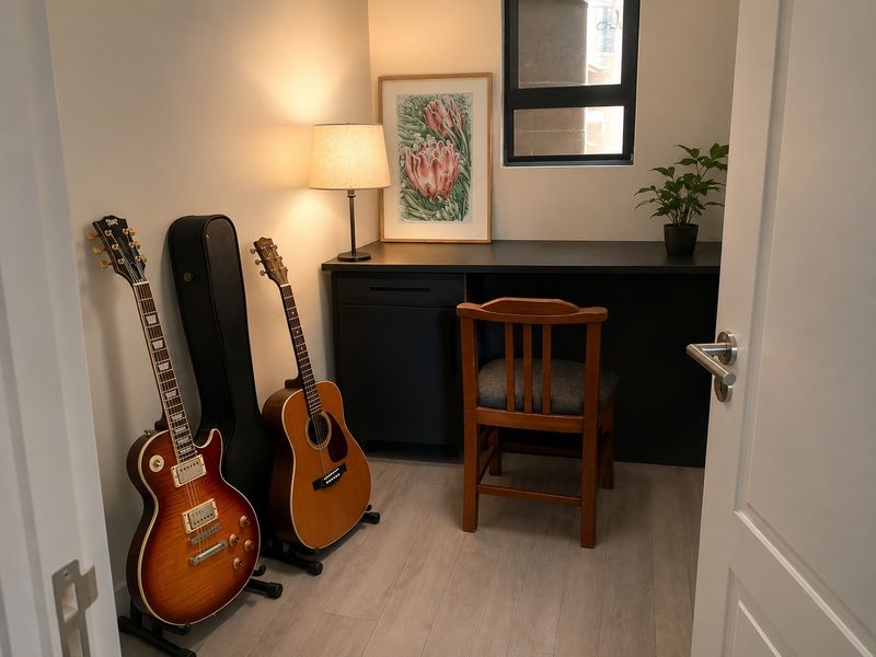 A compact home office featuring a built-in desk, modern laminate flooring, and a window, providing a functional workspace.