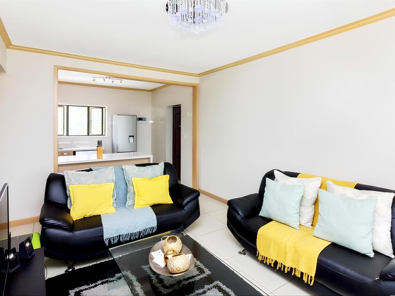 Open plan living area featuring tiled flooring and a seamless transition into the adjacent kitchen space.
