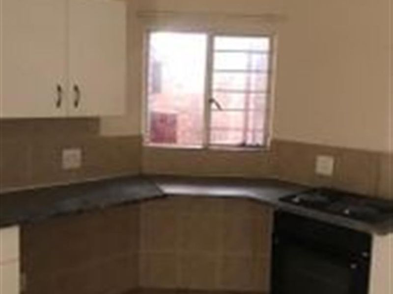 A functional kitchen featuring built-in cabinetry, laminate countertops, a built-in oven and hob, and tiled flooring.