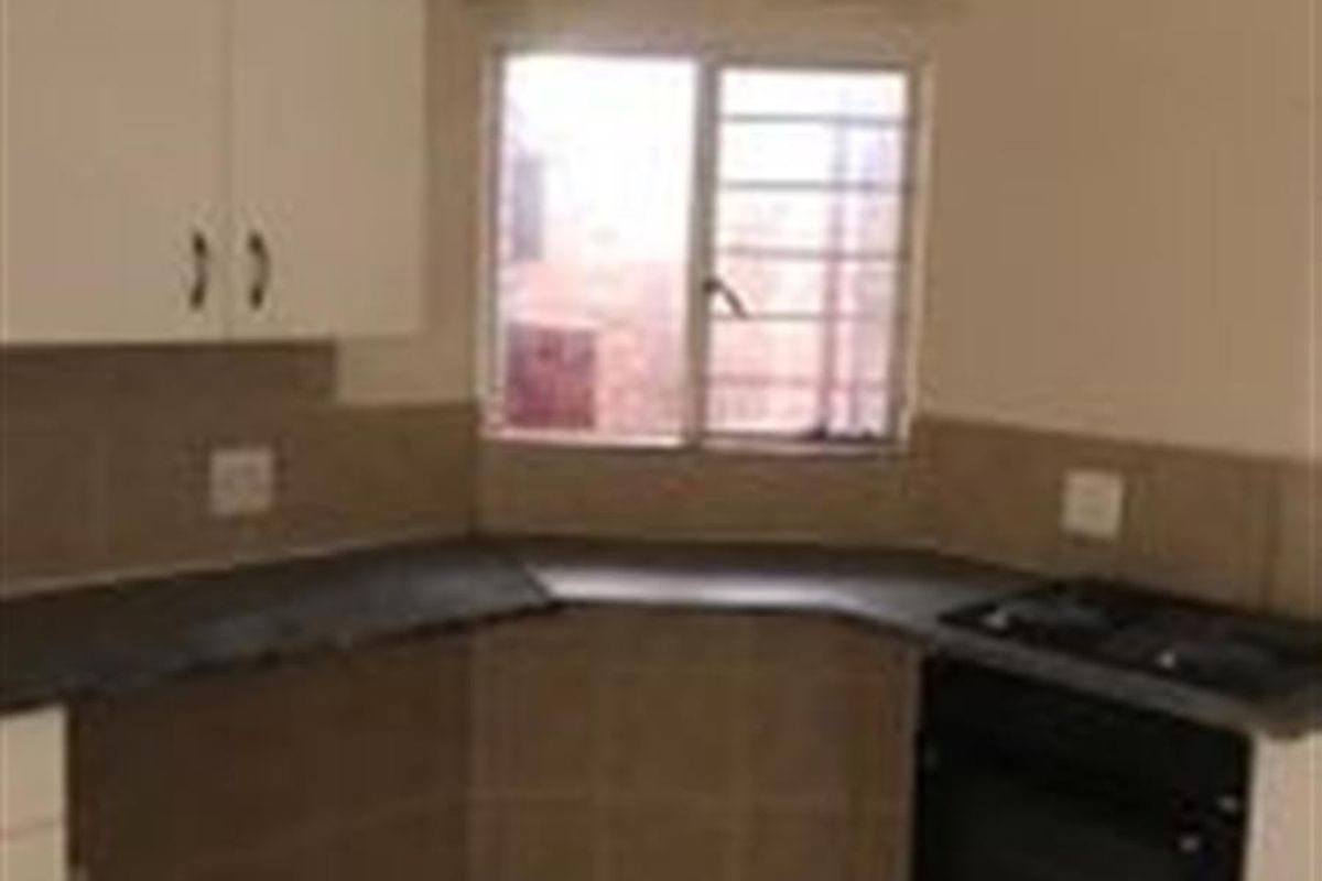 A functional kitchen featuring built-in cabinetry, laminate countertops, a built-in oven and hob, and tiled flooring.