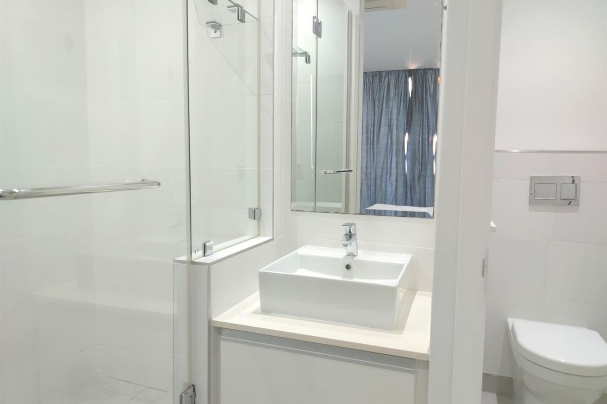 Modern bathroom featuring a glass-enclosed shower, a contemporary vessel sink vanity, and a wall-mounted toilet with a concealed cistern.