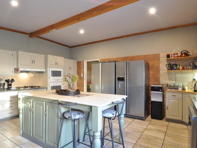 Spacious kitchen featuring a central island, built-in cabinetry, tiled flooring, and recessed lighting, offering a functional layout for cooking and casual dining.
