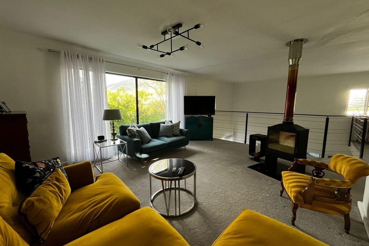 Spacious living room featuring a freestanding fireplace, modern lighting, and large sliding doors that provide natural light and views.