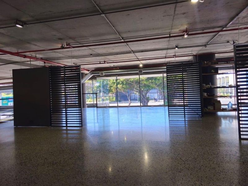 Spacious open-plan retail area featuring polished concrete flooring, exposed industrial ceilings, and large glass windows providing ample natural light.