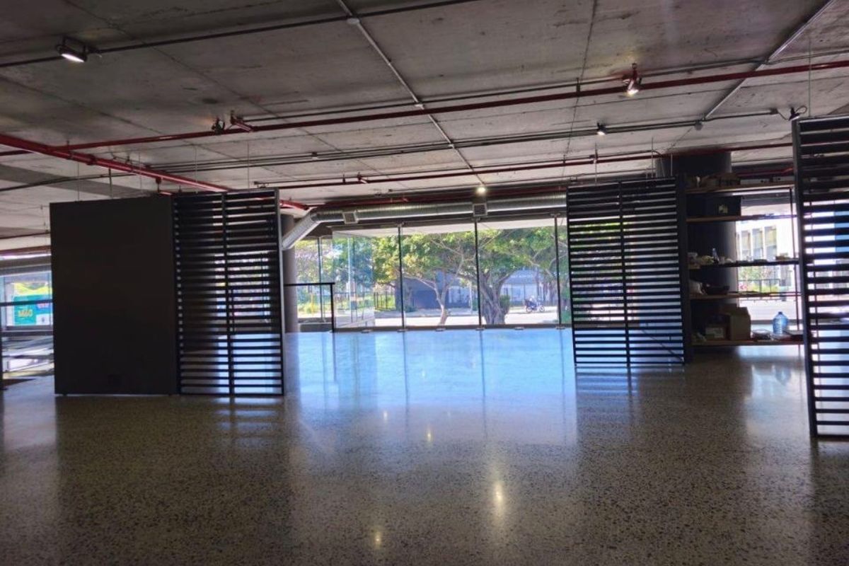 Spacious open-plan retail area featuring polished concrete flooring, exposed industrial ceilings, and large glass windows providing ample natural light.
